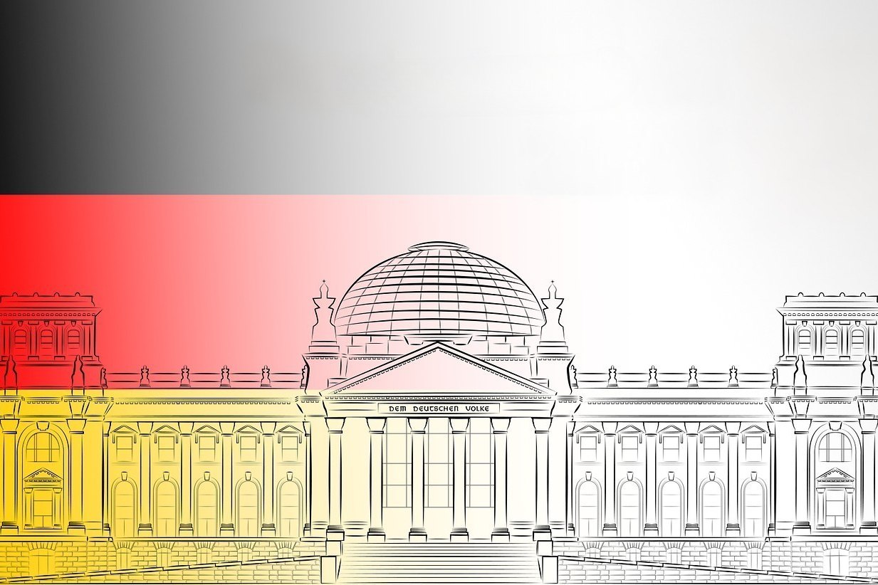 Vor dem Hintergrund der deutschen Nationalfarben ist der Berliner Reichstag als zentrales Symbol der Demokratie dargestellt. 
