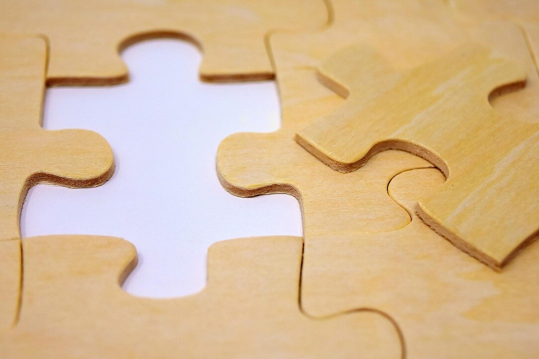 Teile eines zusammengesetzten Holzpuzzles, bei dem ein Teil fehlt.