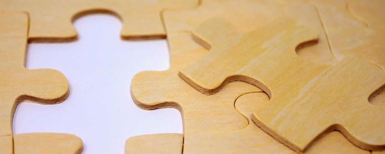 Teile eines zusammengesetzten Holzpuzzles, bei dem ein Teil fehlt.