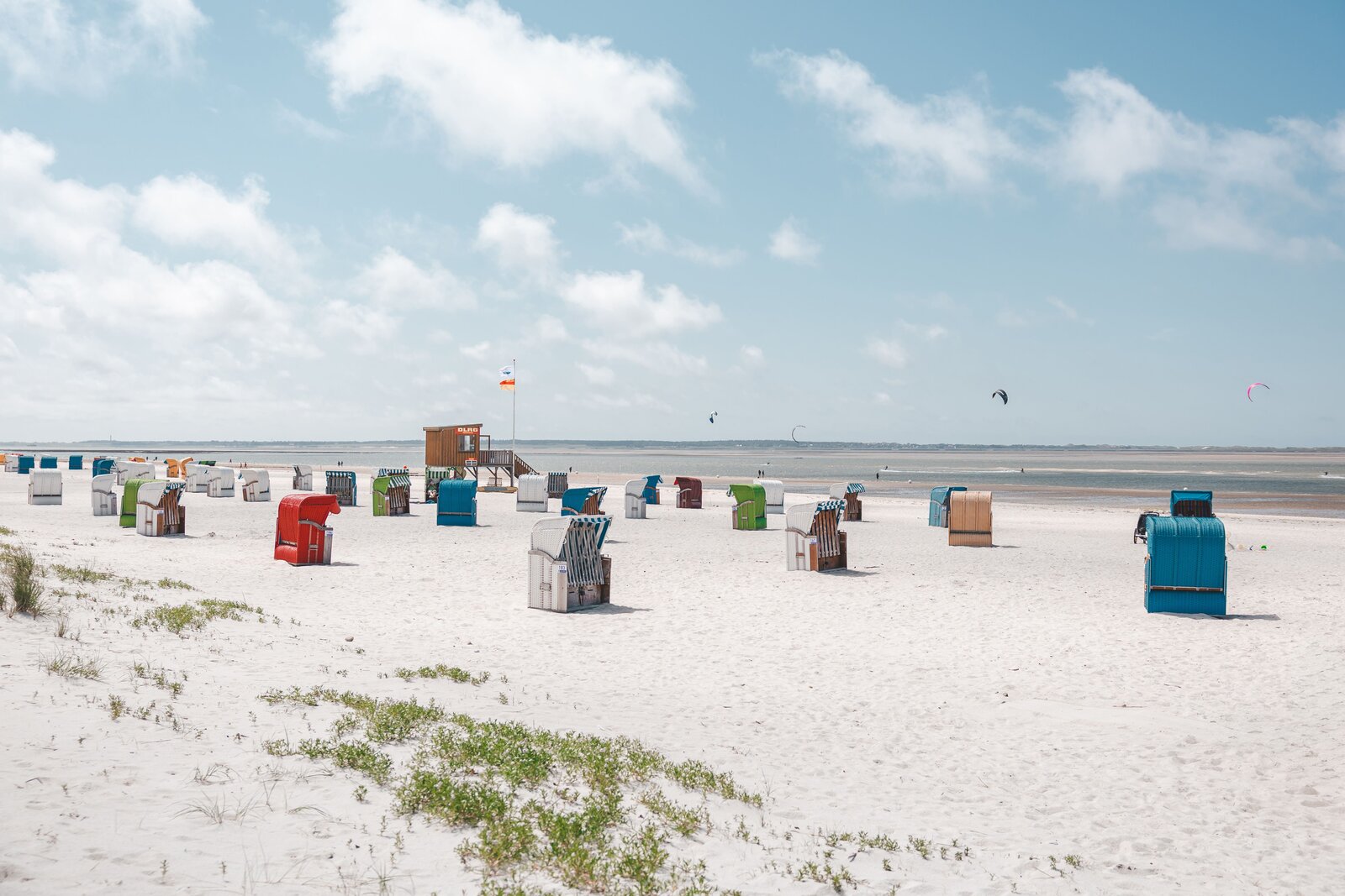 Bunte Strandkörbe am Strand von Föhr, im Hintergrund das Meer